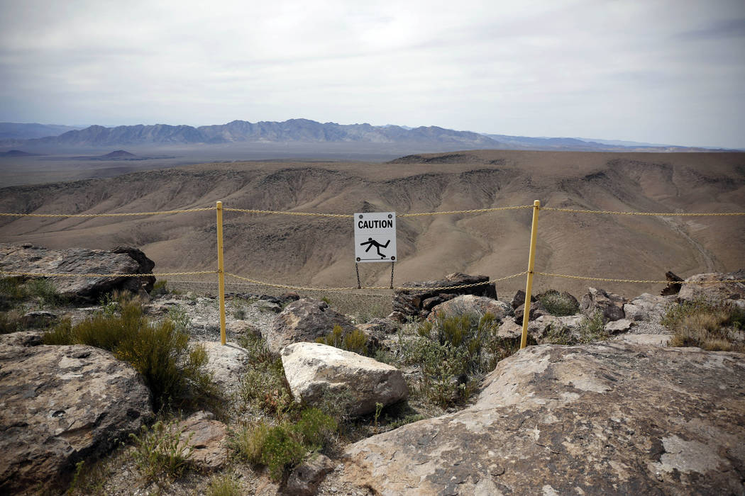 In this April 9, 2015, file photo, a sign warns of fall danger on the crest of Yucca Mountain during a congressional tour near Mercury, Nev. Nevada is telling the Nuclear Regulatory Commission som ...