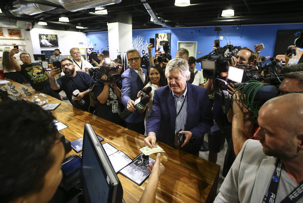 Sen. Tick Segerblom, D-Las Vegas, hands over cash to be the first customer to buy recreational marijuana at Reef Dispensaries in Las Vegas on Saturday, July 1, 2017. Chase Stevens Las Vegas Review ...
