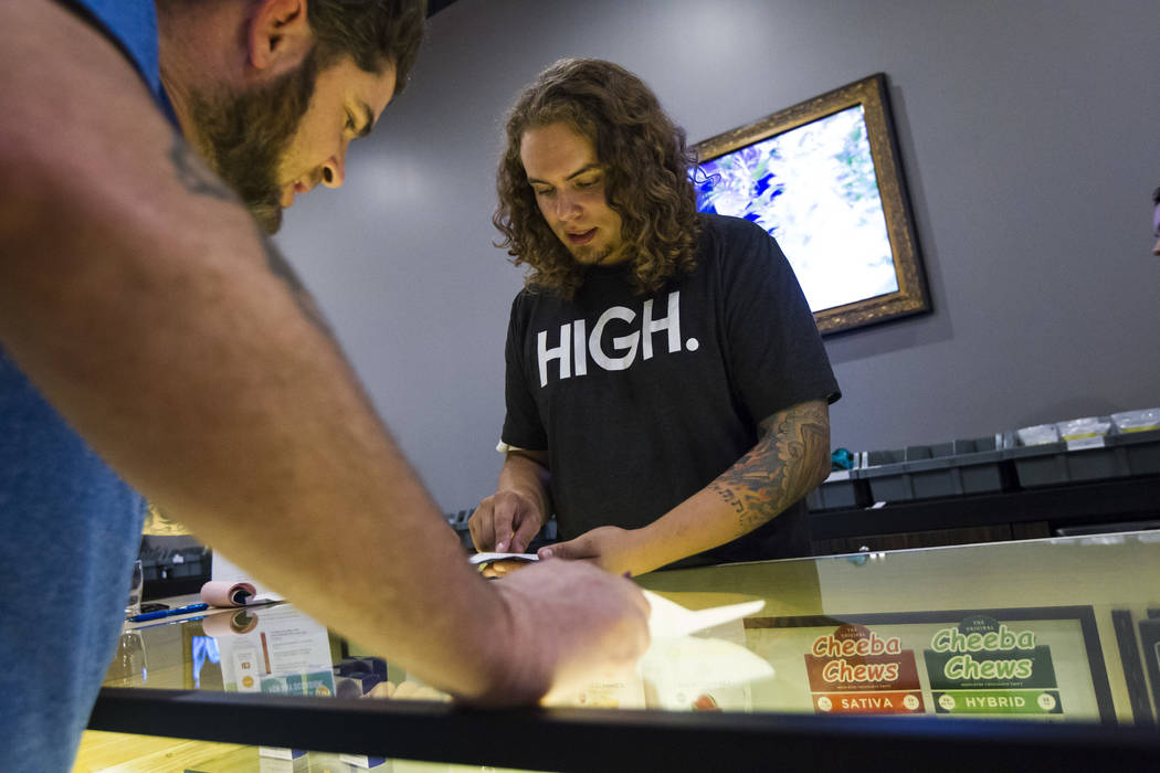 Budtender Tom Nieves, right, assists customer Ethan, of Henderson, during the first day of recreational marijuana sales at Acres Cannabis in Las Vegas on Saturday, July 1, 2017. Chase Stevens Las  ...