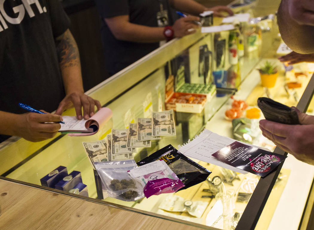 Henderson resident Ethan, right, purchases marijuana products during the first day of recreational sales at Acres Cannabis in Las Vegas on Saturday, July 1, 2017. Chase Stevens Las Vegas Review-Jo ...