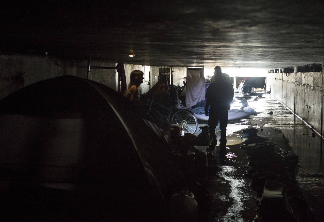 HELP of Southern Nevada employees Oscar Landgrabe, front right, and Louis Lacey ask Sheila North, left, if she needs help in flood tunnels near the Hard Rock hotel- casino on Tuesday, June 27, 201 ...