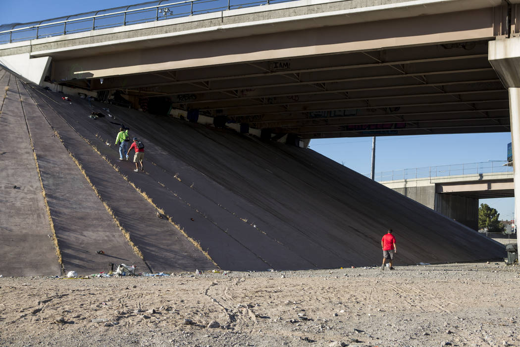 HELP of Southern Nevada employee Louis Lacey, the Mobile Crisis Intervention Team manager, climbs up an underpass beneath Interstate 15 while U.S. Vets team members follow near the Rio hotel-casin ...