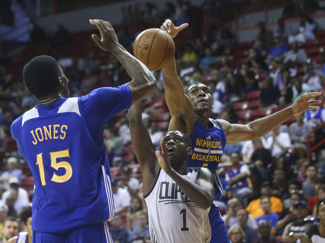 Los Angeles Clippers' Jawun Evans (1) is blocked by Golden State Warriors' Kevon Looney, right, with the help of teammate Damian Jones (15) during a basketball game at the NBA Summer League at the ...