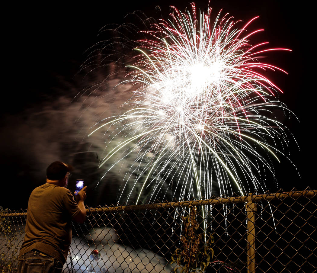 A man watches a fireworks display for Independence Day at Worlds of Fun amusement park Monday, July 3, 2017, in Kansas City, Mo. (Charlie Riedel/AP)