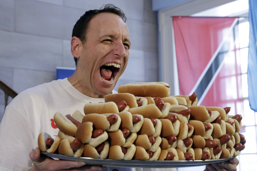 Current men's champion Joey Chestnut, of San Jose, Calif., holds a tray of hot dogs during the weigh-in for the 2017 Nathan's Hot Dog Eating Contest, in Brooklyn Borough Hall, in New York, Monday, ...