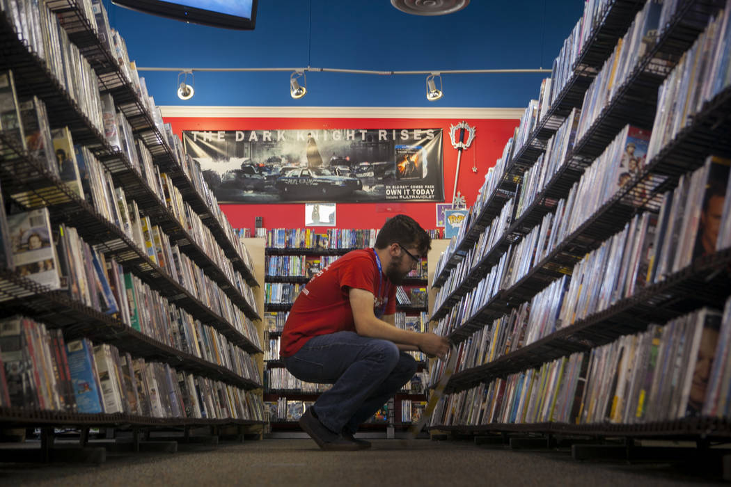 An employee works a movie section at a Vintage Stock store in Kansas City, Missouri. Vintage Stock is one of two companies owned by Las Vegas Valley-based holding company Live Ventures. (Vintage S ...