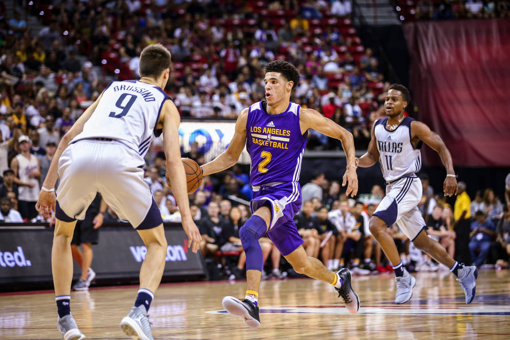 Los Angeles Lakers guard Lonzo Ball goes up against Dallas Mavericks guards Nicolas Brussino and Yogi Ferrell during the NBA Summer League semifinal game at Thomas and Mack Center on Sunday, July  ...