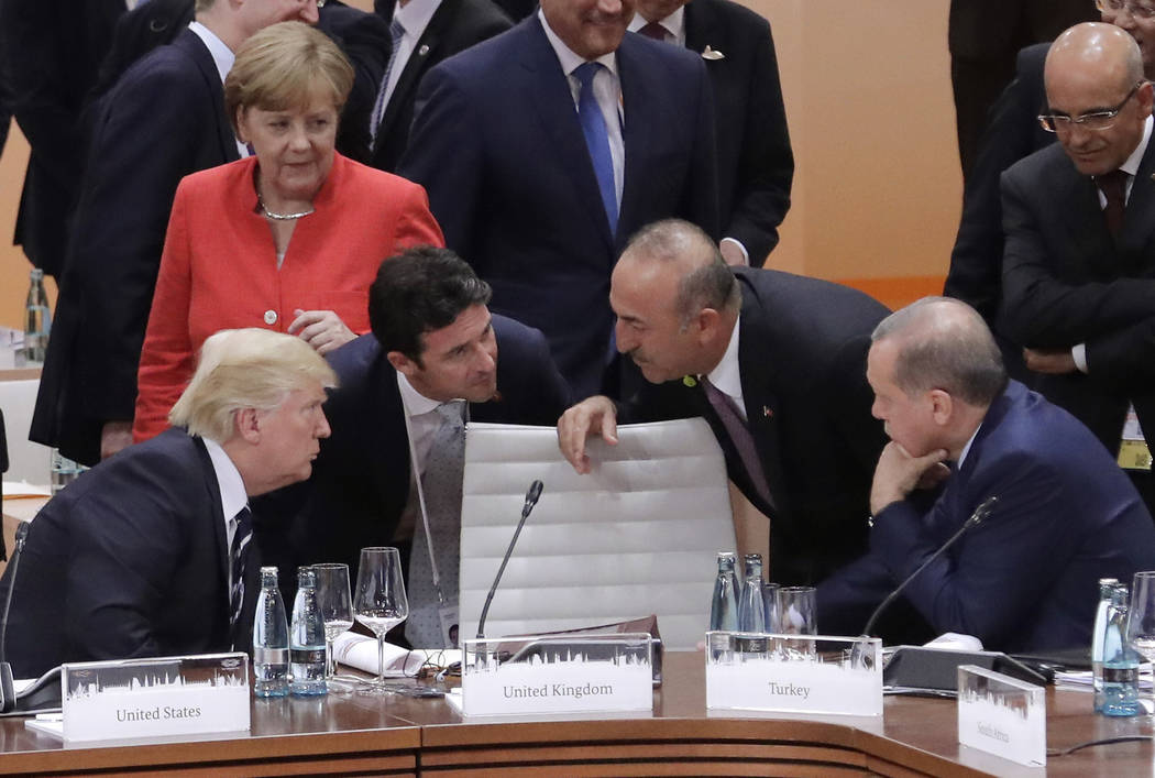 German Chancellor Angela Merkel looks on as President Donald Trump, left, talks to Turkey's Foreign Minister Mevlut Cavusoglu and Turkish President Recep Tayyip Erdogan, right, prior to the first  ...