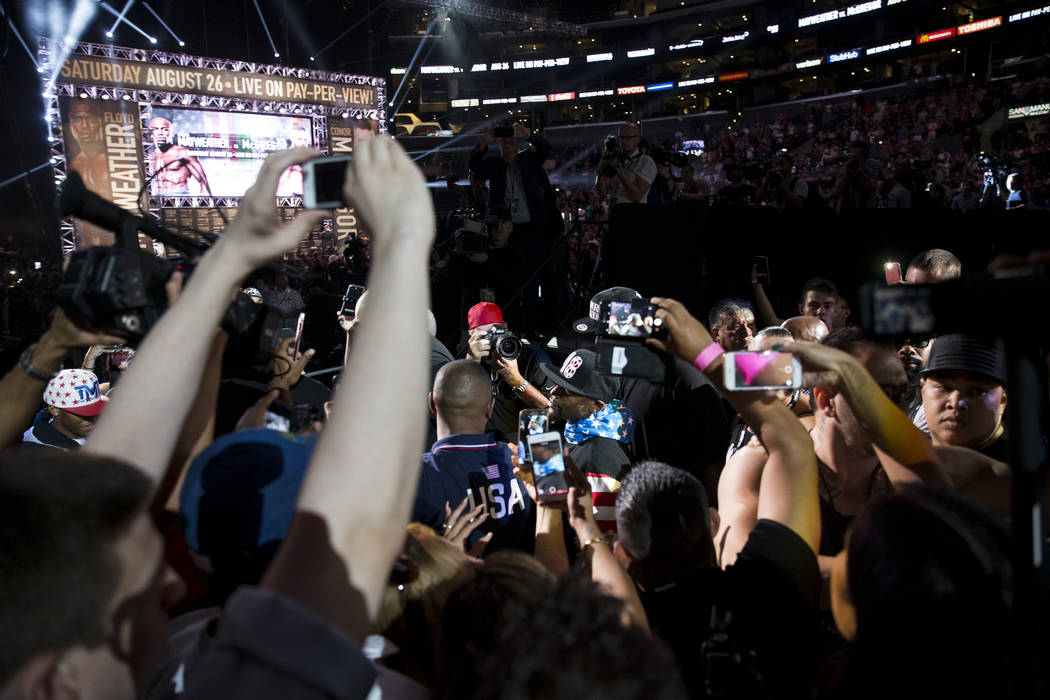 Boxer Floyd Mayweather Jr., center, was to the stage for a world tour event stop to promote his upcoming fight against UFC fighter Conor McGregor, at Staples Center in Los Angeles, Calif., on Tues ...