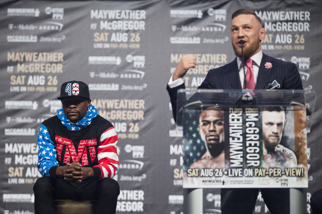 UFC fighter Conor McGregor, right, during a world tour event stop to promote his upcoming fight against Boxer Floyd Mayweather Jr., left, at Staples Center in Los Angeles, Calif., on Tuesday, July ...