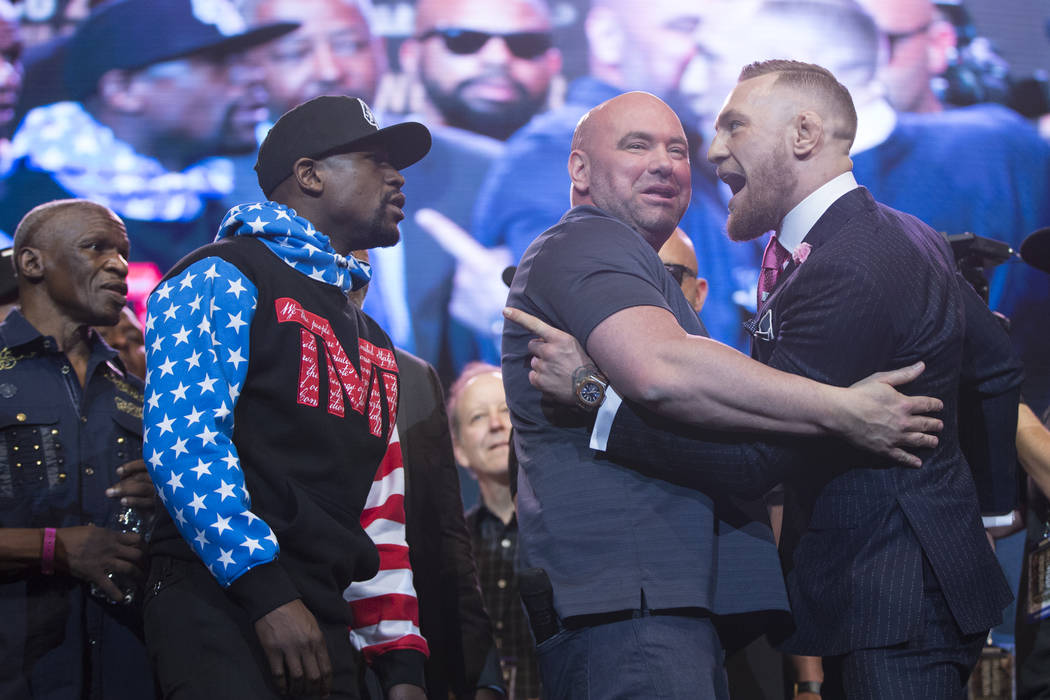 Boxer Floyd Mayweather Jr., left, and UFC fighter Conor McGregor, right, with UFC president Dana White, during a press conference in their world boxing tour to promote their upcoming fight, at Sta ...