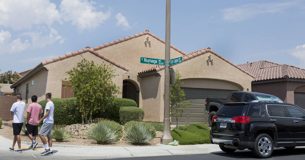 People walk passed the home of John Lunetta, 10337 S. Numaga Road, where the bodies were found Monday night  in Las Vegas, Tuesday, July 11, 2017. Las Vegas police said a man fatally shot his girl ...