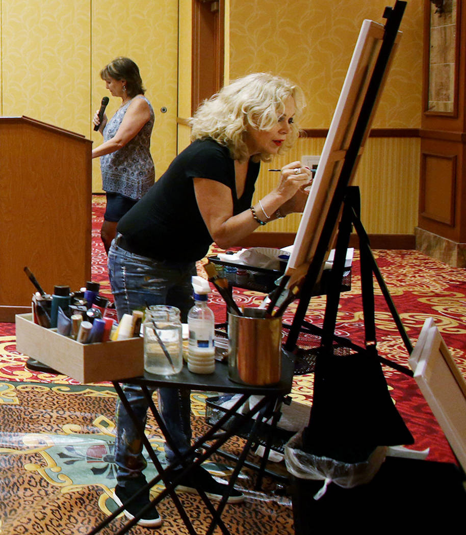 Author Linda Lou speaks while artist Meegan Boiros paints during an event, Painted Stories “Endless Summer,&quot; on Sunday, July 16, 2017, at the South Point.  Rachel Aston Las Vegas R ...