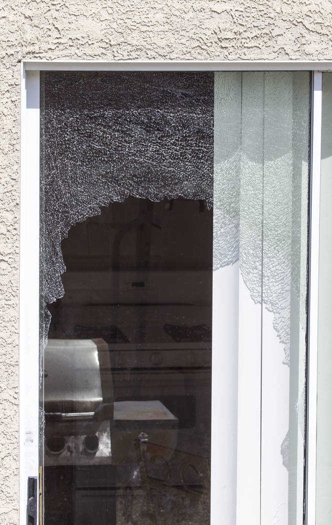 A shattered sliding glass door at a residence in the 5000 block of Droubay Drive in the Squire Village in Las Vegas on Thursday, July 13, 2017.  Neighbors called the police on Wednesday after they ...
