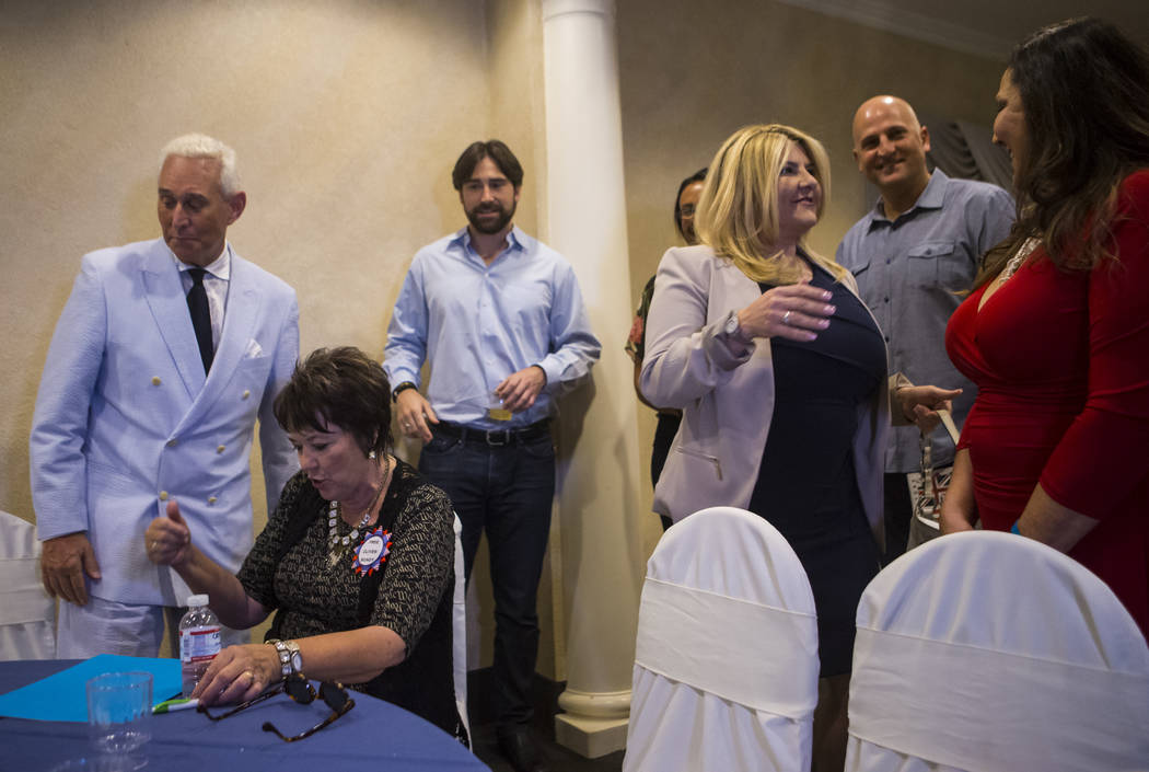 Political consultant Roger Stone, left, talks with Carol Bundy, second from left, as Las Vegas City Councilwoman Michele Fiore, fourth from left, greets people at a fundraising event in support of ...