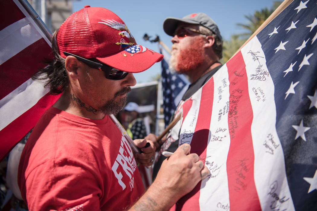 Lanahan Russell, Virginia resident, signs a flag at a rally to support defendants in the Bundy standoff case at the Lloyd George U.S. Courthouse on Saturday, July 15, 2017, in Las Vegas. Morgan Li ...