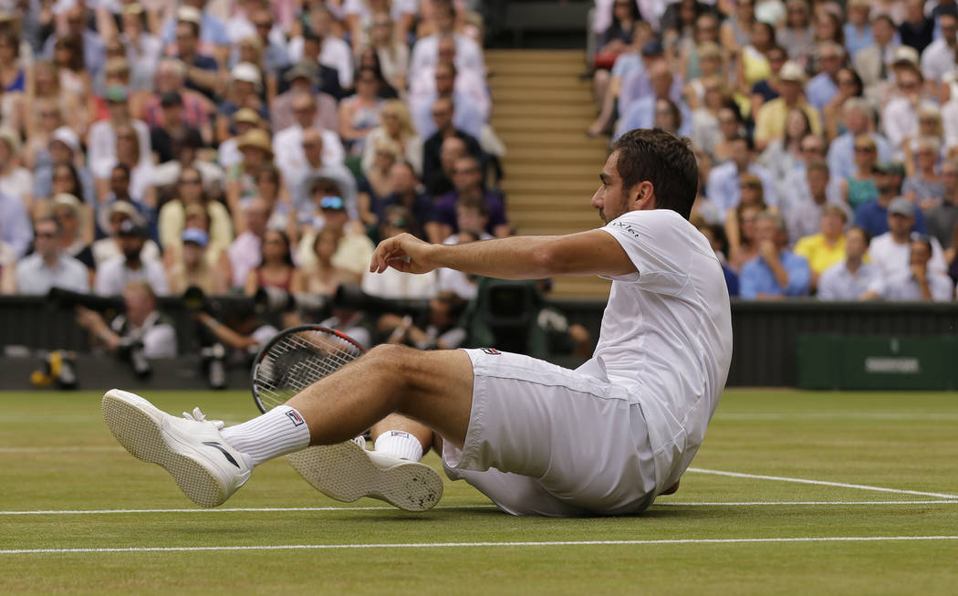 Croatia's Marin Cilic takes a tumble after returning to Switzerland's Roger Federer in the Men's Singles final match on day thirteen at the Wimbledon Tennis Championships in London Sunday, July 16 ...