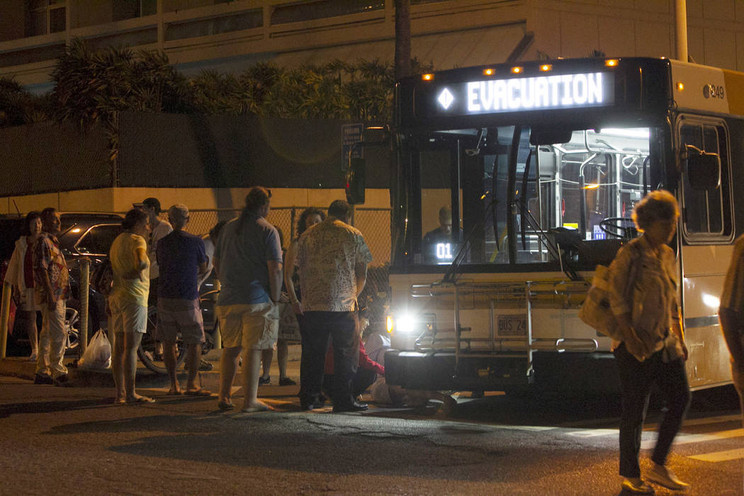 An evacuation bus takes residents of the Marco Polo building to a nearby shelter after a deadly fire at the building, Friday, July 14, 2017, in Honolulu. (Marco Garcia/AP)