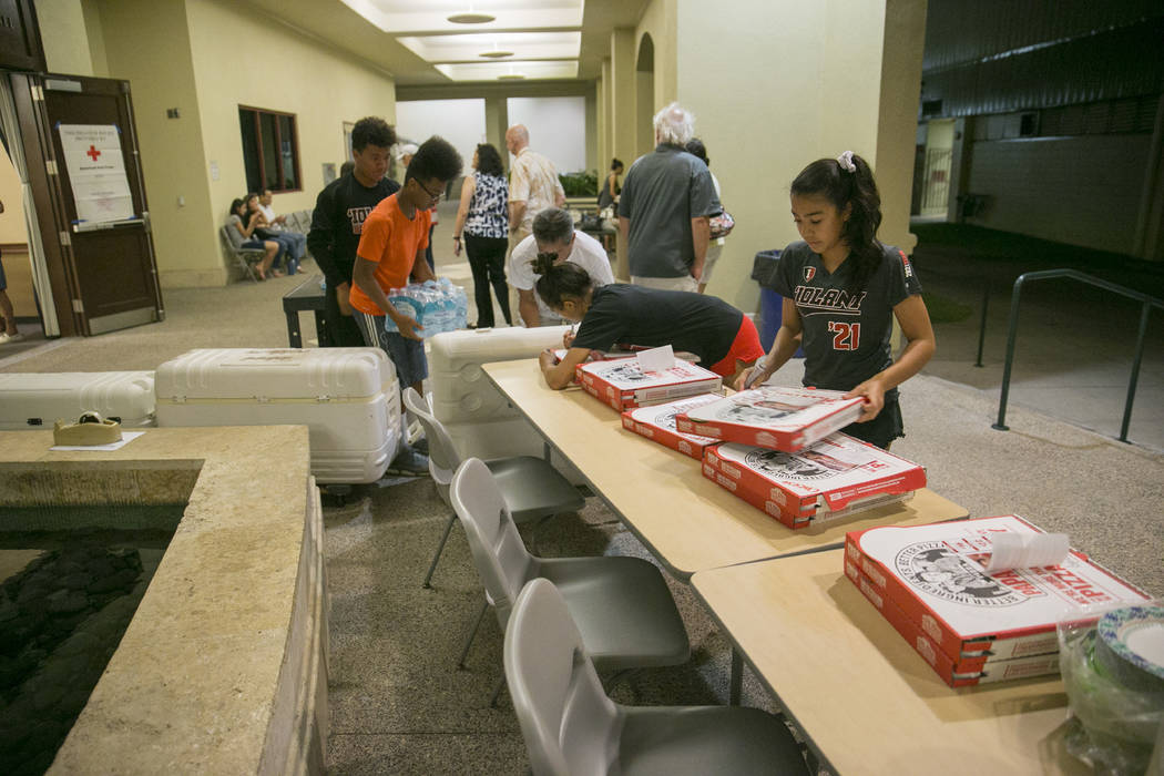 Volunteers prepare food and drinks at a school for the residents of the Marco Polo building, Friday, July 14, 2017, in Honolulu. A deadly fire broke out in the building killing three people and se ...