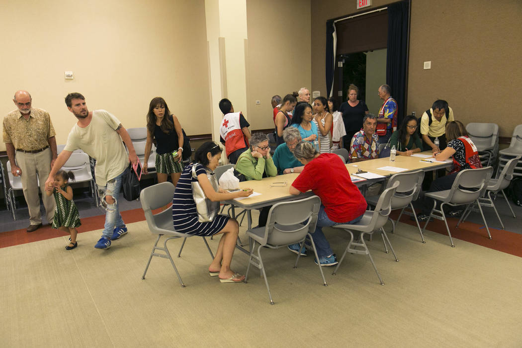 Residents of the Marco Polo building register at a shelter for overnight accommodations after a deadly fire tore through the high rise building, Friday, July 14, 2017, in Honolulu. (Marco Garcia/AP)