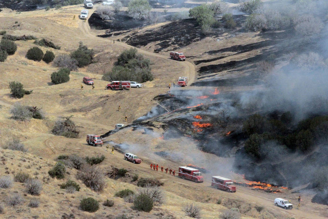 Firefighting crews from the California Department of Forestry and Fire Protection (CAL FIRE) move into position to fight the Garza fire as California Army National Guard helicopters fly overhead a ...