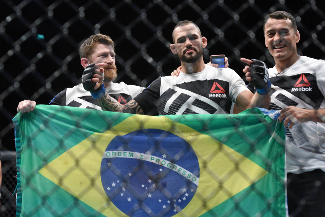 Santiago Ponzinibbio (blue gloves) poses with his corner crew after defeating Gunnar Nelson (not pictured) during UFC Fight Night at SSE Hydro. (Per Haljestam-USA TODAY Sports)
