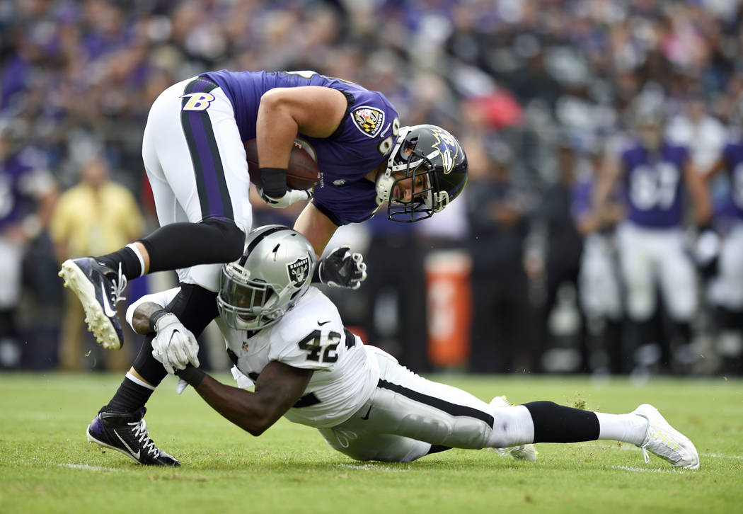 Baltimore Ravens tight end Dennis Pitta, top, is tackled by Oakland Raiders safety Karl Joseph as he rushes the ball in the first half of an NFL football game, Sunday, Oct. 2, 2016, in Baltimore.  ...