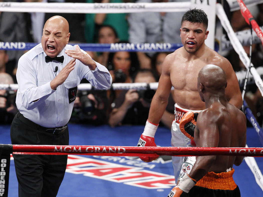 Referee Joe Cortez calls time after Victor Ortiz, top right, head butted Floyd Mayweather in the fourth round during a WBC welterweight title fight, Saturday, Sept. 17, 2011, in Las Vegas. Mayweat ...
