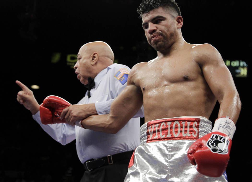 Victor Ortiz, right, has a point taken from him by referee Joe Cortez after a head butt on Floyd Mayweather Jr. during their WBC welterweight title fight Saturday, Sept. 17, 2011, in Las Vegas. Ma ...