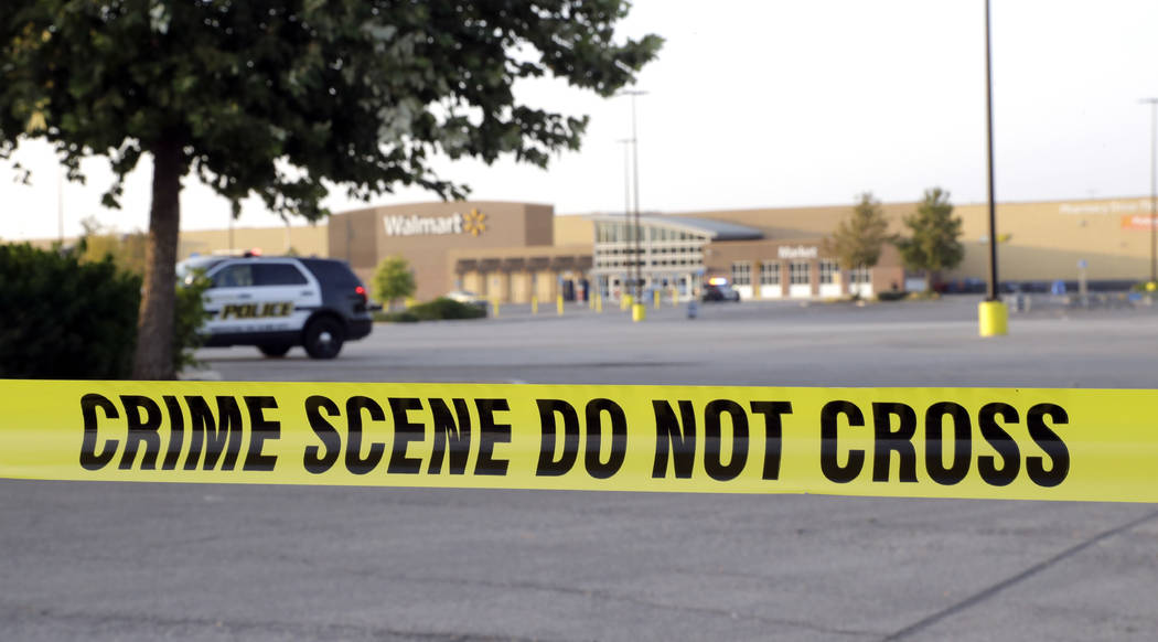 San Antonio police officers investigate the scene where eight people were found dead in a tractor-trailer loaded with at least 30 others outside a Walmart store in stifling summer heat in what pol ...