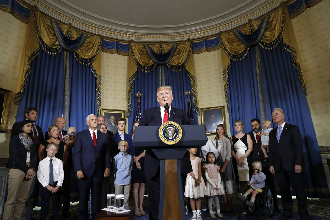 President Donald Trump, accompanied by Vice President Mike Pence, Health and Human Services Secretary Tom Price, and others, speaks about healthcare, Monday, July 24, 2017, in the Blue Room of the ...