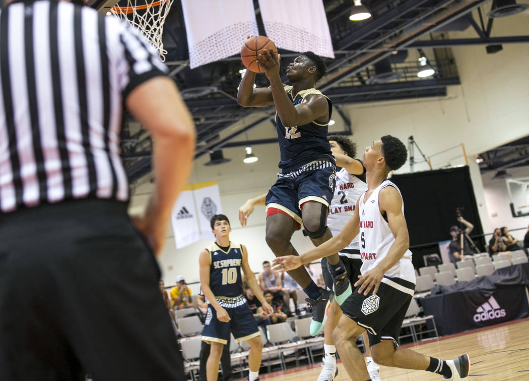 SC Supreme forward Zion Williamson (12) goes up for a shot over Play Hard Play Smart's Julice Hamilton (2) and Zachary Chappell (5) during an Adidas Uprising Summer Championship basketball game at ...