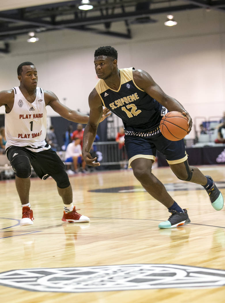 SC Supreme forward Zion Williamson (12) drives to the basket while defended by Play Hard Play Smart's Tre'Quan Jones (1) during an Adidas Uprising Summer Championship basketball game at Cashman Ce ...