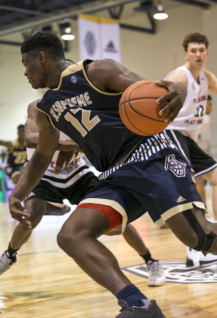 SC Supreme forward Zion Williamson (12) drives the ball under as he is pressured by Play Hard Play Smart defenders during an Adidas Uprising Summer Championship basketball game at Cashman Center,  ...