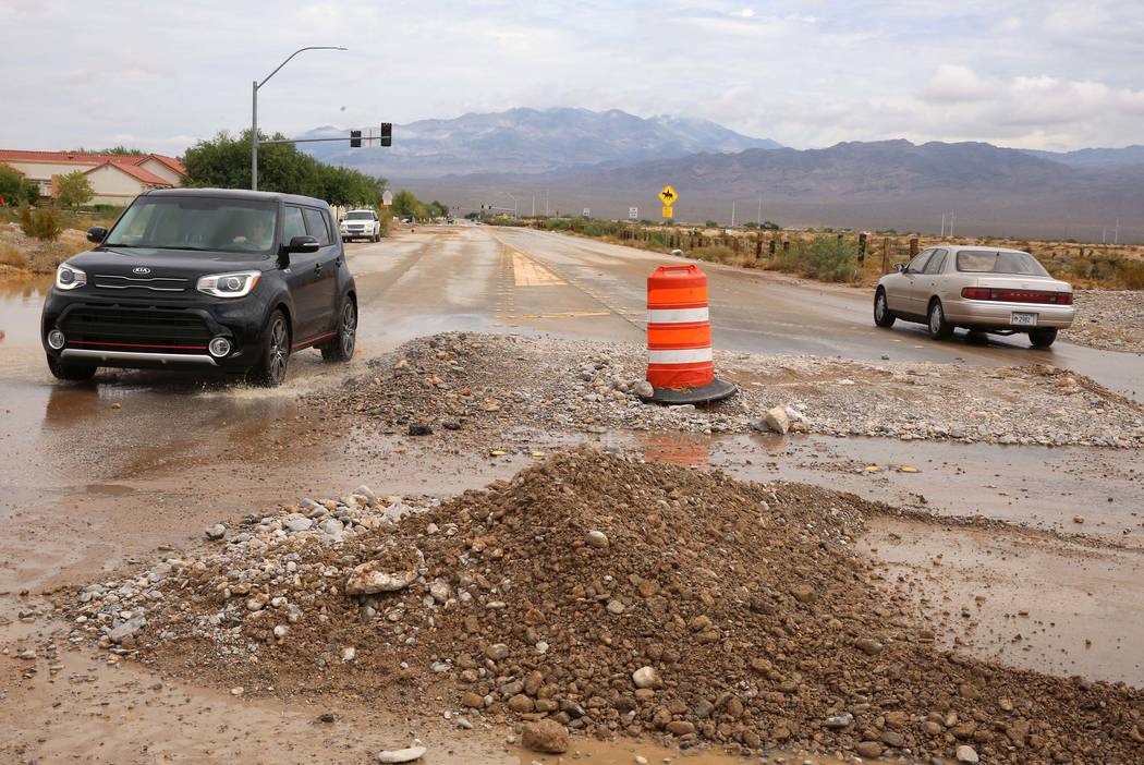 Motorists drive past flood debris left behind at the intersection of Durango Drive and Brent Lane on Tuesday, July 25, 2017, in Las Vegas. (Bizuayehu Tesfaye/Las Vegas Review-Journal) @bizutesfaye