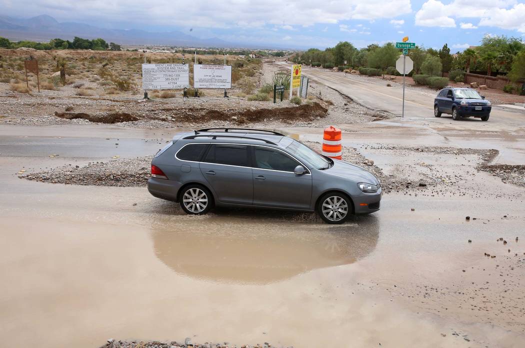 Motorists navigate through flooded street at the intersection of Durango Drive and Brent Lane on Tuesday, July 25, 2017, in Las Vegas. (Bizuayehu Tesfaye/Las Vegas Review-Journal) @bizutesfaye