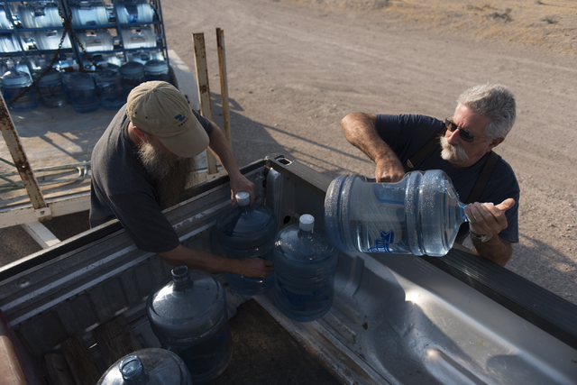 Southern Inyo Fire Protection District chief Larry Levy, right, and Jim Furlough make their weekly potable water delivery rounds to residents in Tecopa, Calif., on June 21, 2016. The delivery serv ...