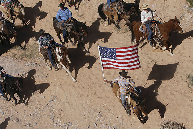 The Bundy family and its supporters fly the American flag as the family’s cattle is released by the Bureau of Land Management back onto public land outside of Bunkerville on April 12, 2014. (Jas ...