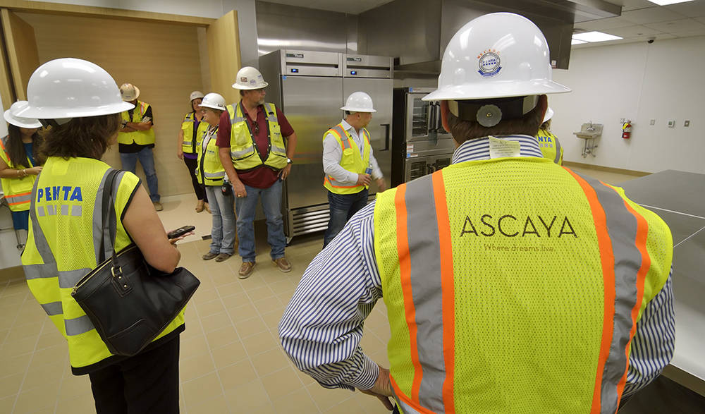The Ascaya crew look over the  Wolfgang Puck-designed kitchen. (Bill Hughes Real Estate Millions)