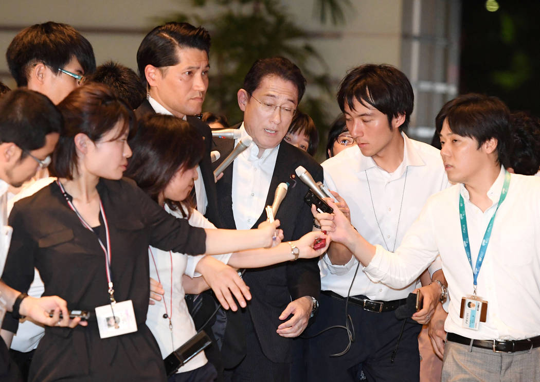 Japan's Foreign Minister Fumio Kishida, center, who is also currently taking role as defense minister, is surrounded by reporters upon his arrival at prime minister's house after reports on North  ...