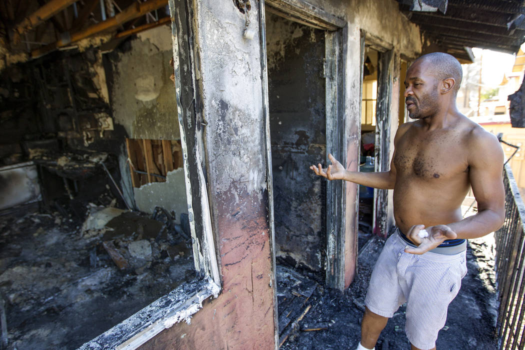 Mulberry Park Apartments resident Chris Cooper debates going into his unit to salvage personal belongings after his apartment was destroyed in an early morning kitchen fire on Friday, July 28, 201 ...