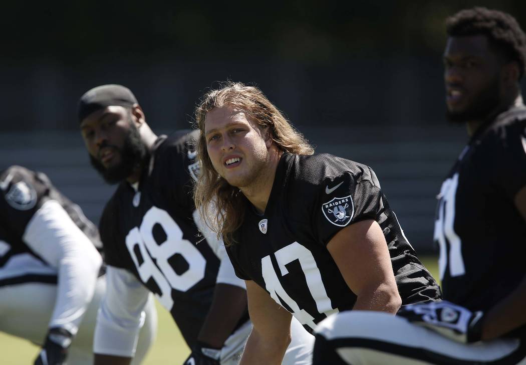 The Oakland Raiders defensive end/linebacker James Cowser, center, stretches during the second day of teams practice at Raiders Napa Valley training complex in Napa., Calif., on Sunday, July 30, 2 ...
