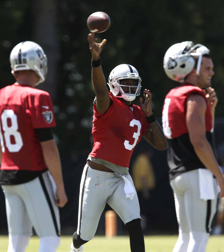 The Oakland Raiders back up quarterback Ej Manuel (3) throws a pass between quarterback Derek Carr, right, and backup quarterback Connor Cook (18) during the second day of teams practice at Raider ...