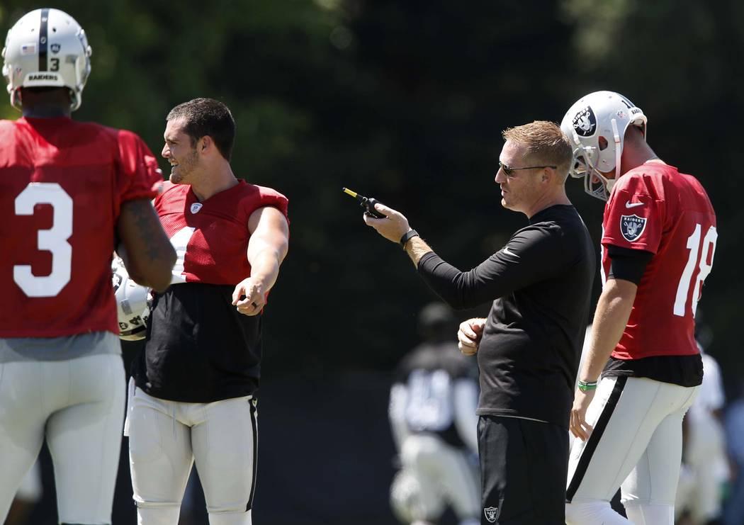The Oakland Raiders offensive coordinator Todd Downing, second right, talks to back up quarterbacks Ej Manuel (3), Connor Cook (18) and quarterback Derek Carr, second left, during the second day o ...