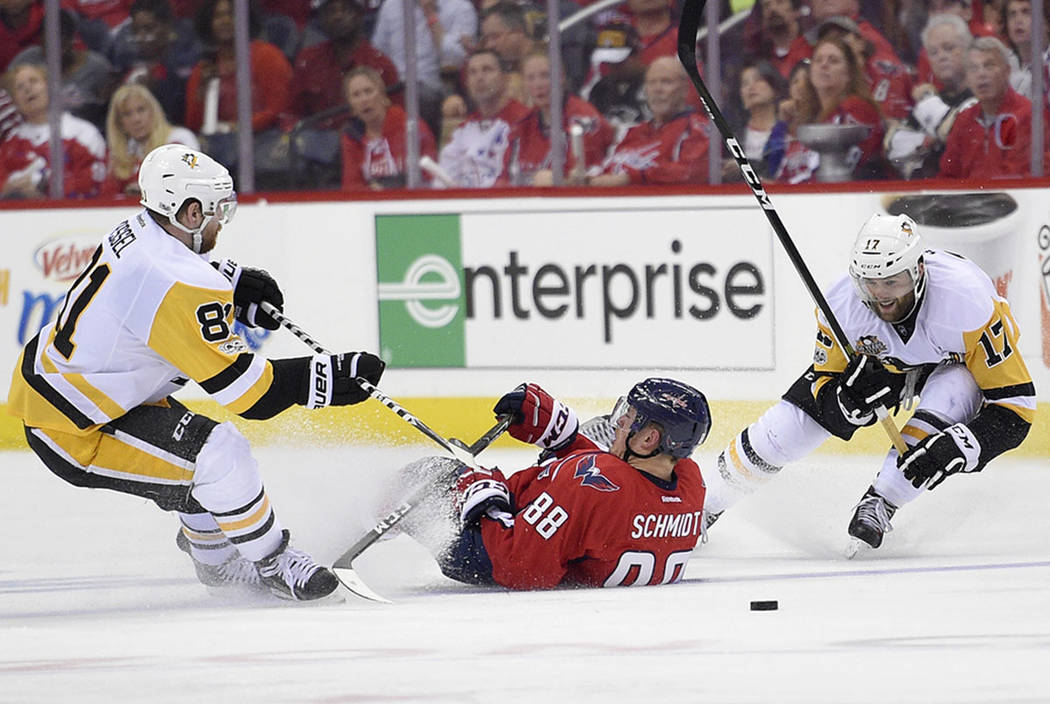 Washington Capitals defenseman Nate Schmidt (88) falls on the ice between Pittsburgh Penguins right wing Phil Kessel (81) and right wing Bryan Rust (17) during the second period of Game 1 in an NH ...