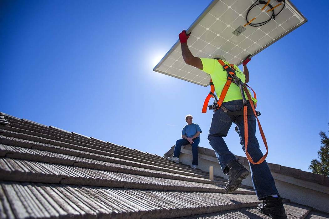 Matt Neifeld with Robco Electric carries a solar panel at a home in northwest Las Vegas on Friday, March 13, 2015. (Jeff Scheid/Las Vegas Review-Journal)