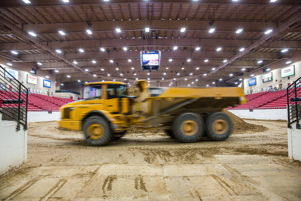 The dump trucks enter the arena from the other end and make a clockwise rotation before stopping for their dirt load. There is little dust kicked up as the base dirt is watered. Monday, July 17, 2 ...