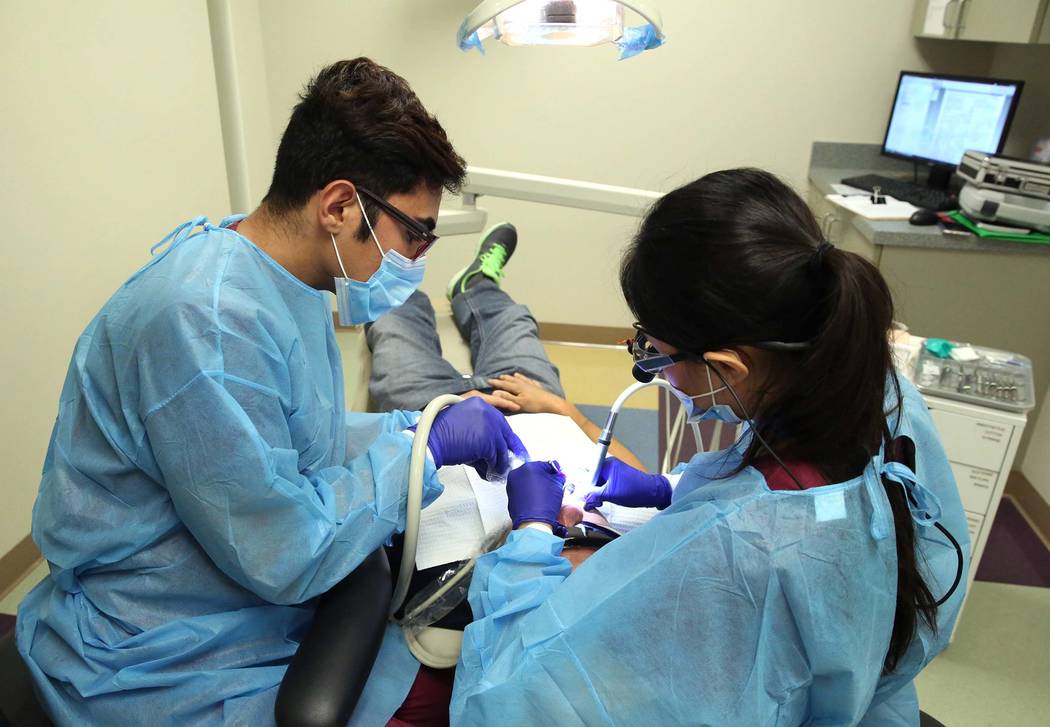 UNLV School of Dental volunteer students, including Alex Sadrossadat, left, treat Nelson Tang at Volunteers In Medicine of Southern Nevada on Monday, July 24, 2017, in Las Vegas. (Bizuayehu Tesfay ...