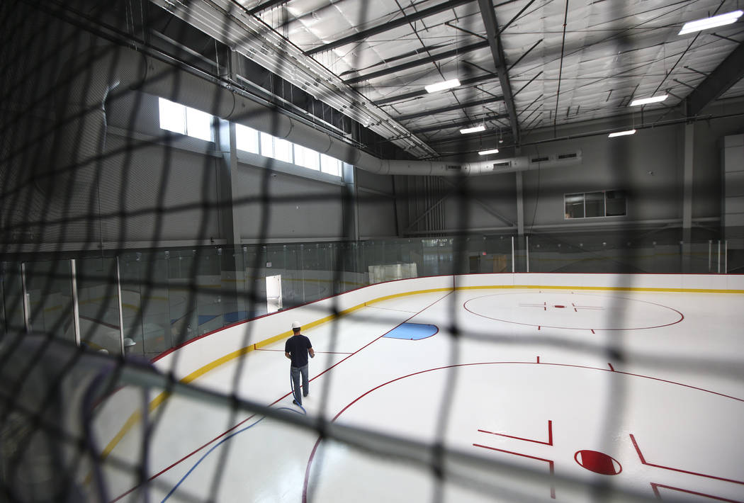 A member of the ice crew puts on the finishing touches on the ice surface of one of two ice rinks at City National Arena, the Vegas Golden Knights' headquarters and training facility, in Las Vegas ...
