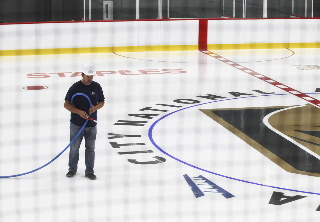 A member of the ice crew puts on the finishing touches on the ice surface of one of two ice rinks at City National Arena, the Vegas Golden Knights' headquarters and training facility, in Las Vegas ...